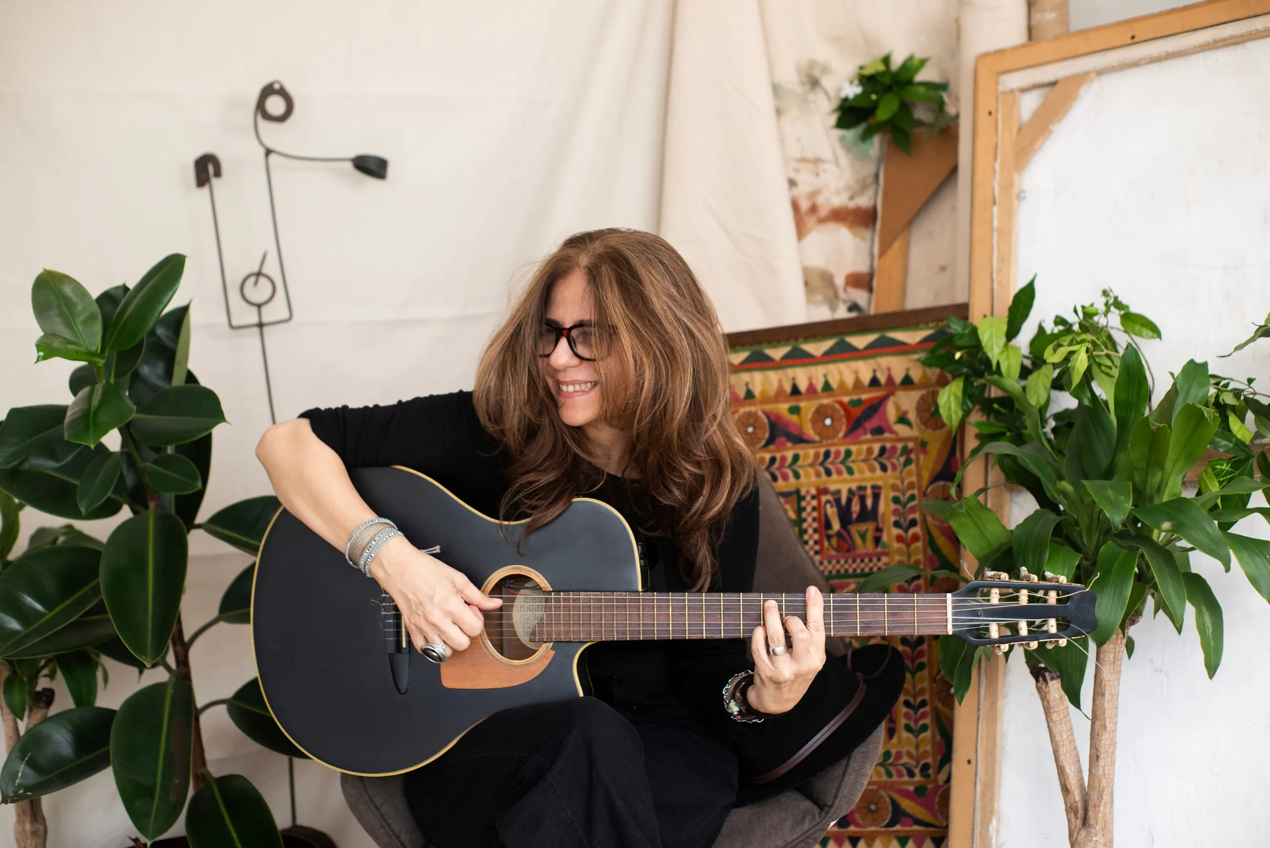 Elsa Basil seated with her guitar