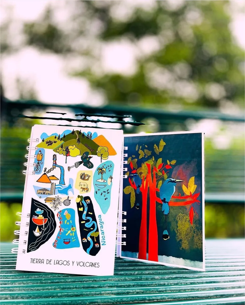Illustrated notebooks standing on a bench, captioned Tierra de lagos y volcanes
